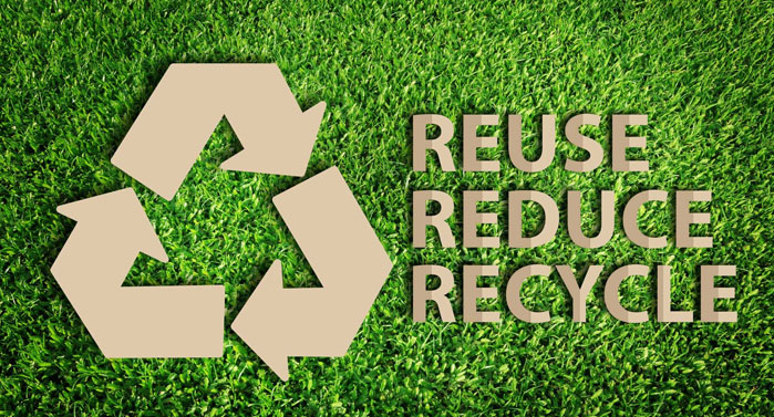 A symbol of Reuse, Reduce and Recycle on green grass