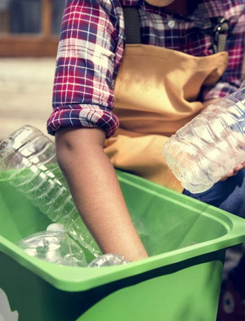 A man dumping plastic bottles in the dustbin